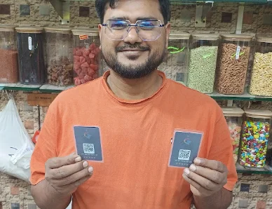 A shop owner holding two TapStar cards, photo from a Google review