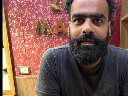 Restaurant owner in Delhi holding his TapStar Google review card at the counter
