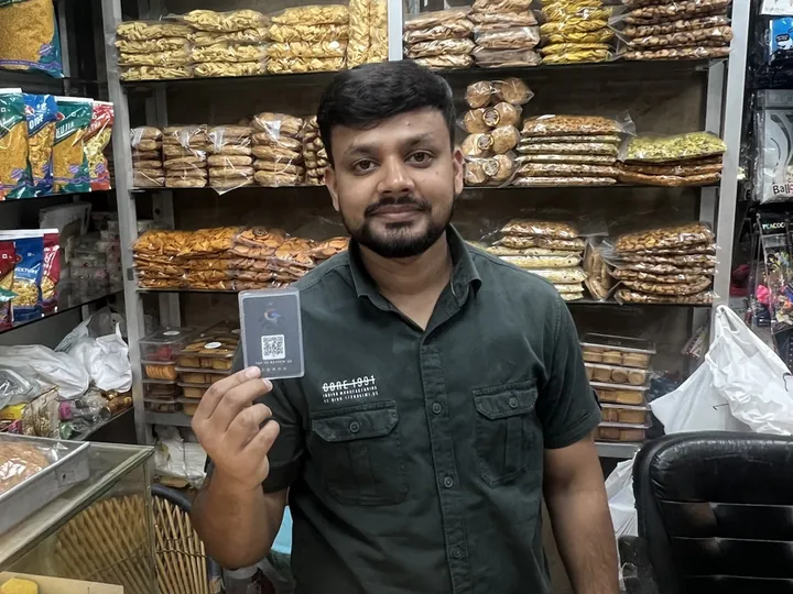 Mr. Adil of AS Bakers holding his TapStar Google review card in his shop