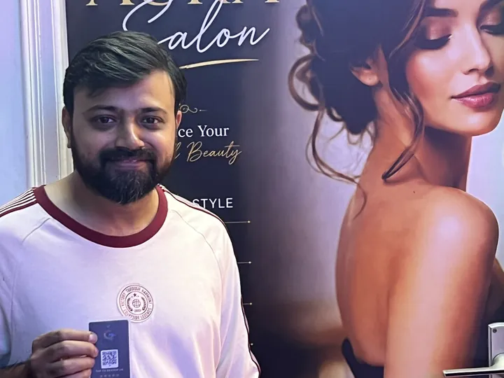 Mr. Altamash of Aura Salon holding his TapStar All-in-One business card